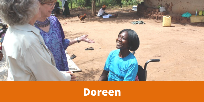 Woman in wheelchair speaking to two other women standing nearby.