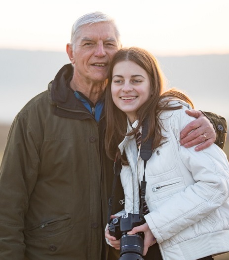 Older man with arm around granddaughter