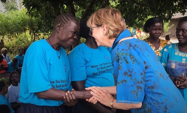 Karon shaking hands with a Ugandan woman.